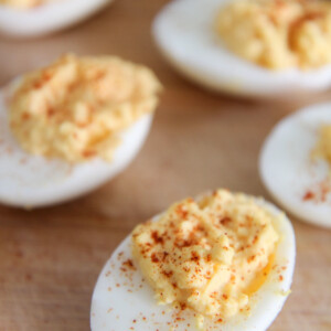 deviled eggs with paprika on a wooden board