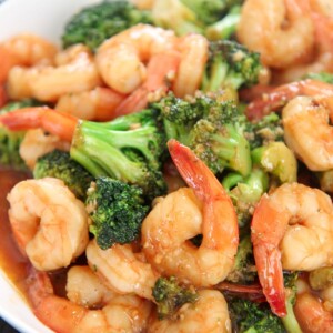 shrimp and broccoli with sauce in a white plate.