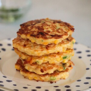 corn fritters stacked on a plate.