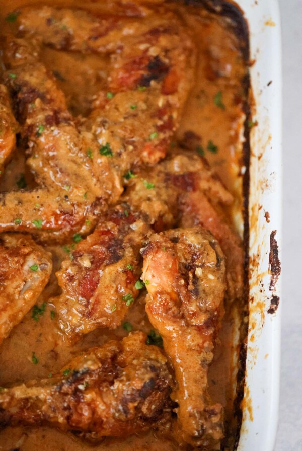 Smothered turkey wings and legs in a baking dish up close.