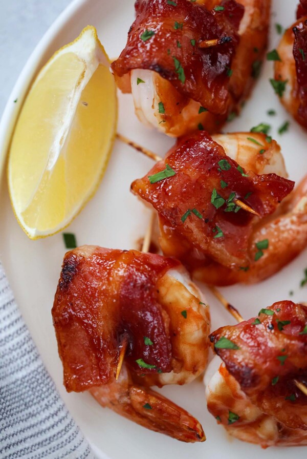 bacon wrapped shrimp with a lemon wedge on the side.