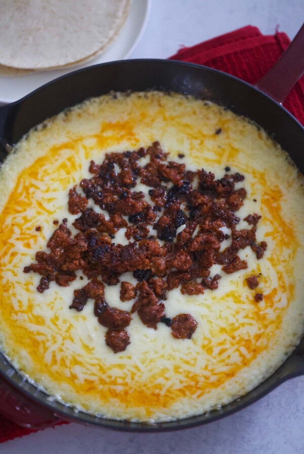 queso fundido in a cast iron skillet.