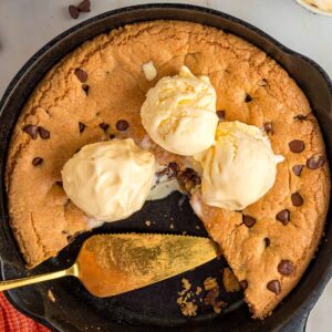 Chocolate chip cookie skillet with three scoops of vanilla ice cream.