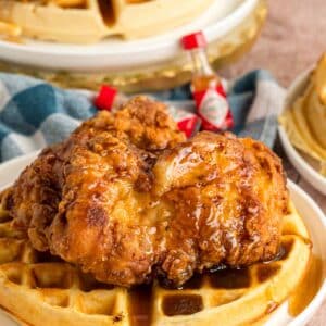 Southern fried chicken and waffles on a white plate.