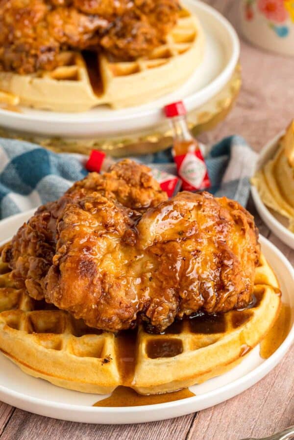 Southern fried chicken and waffles on a white plate.